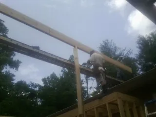 Carpenter setting a ridge beam over a new addition frame — Ice Dam Removal by Roofing Brothers in Keenesburg
