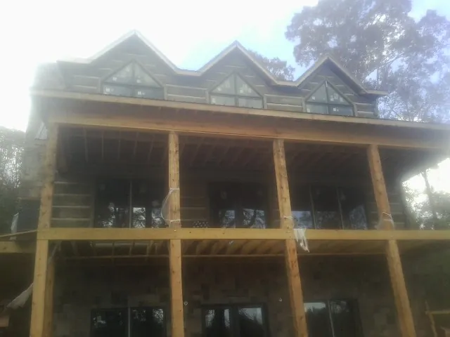 Dormers and porch framing on a large log home under construction — Roof Coating work by our crew in Keenesburg
