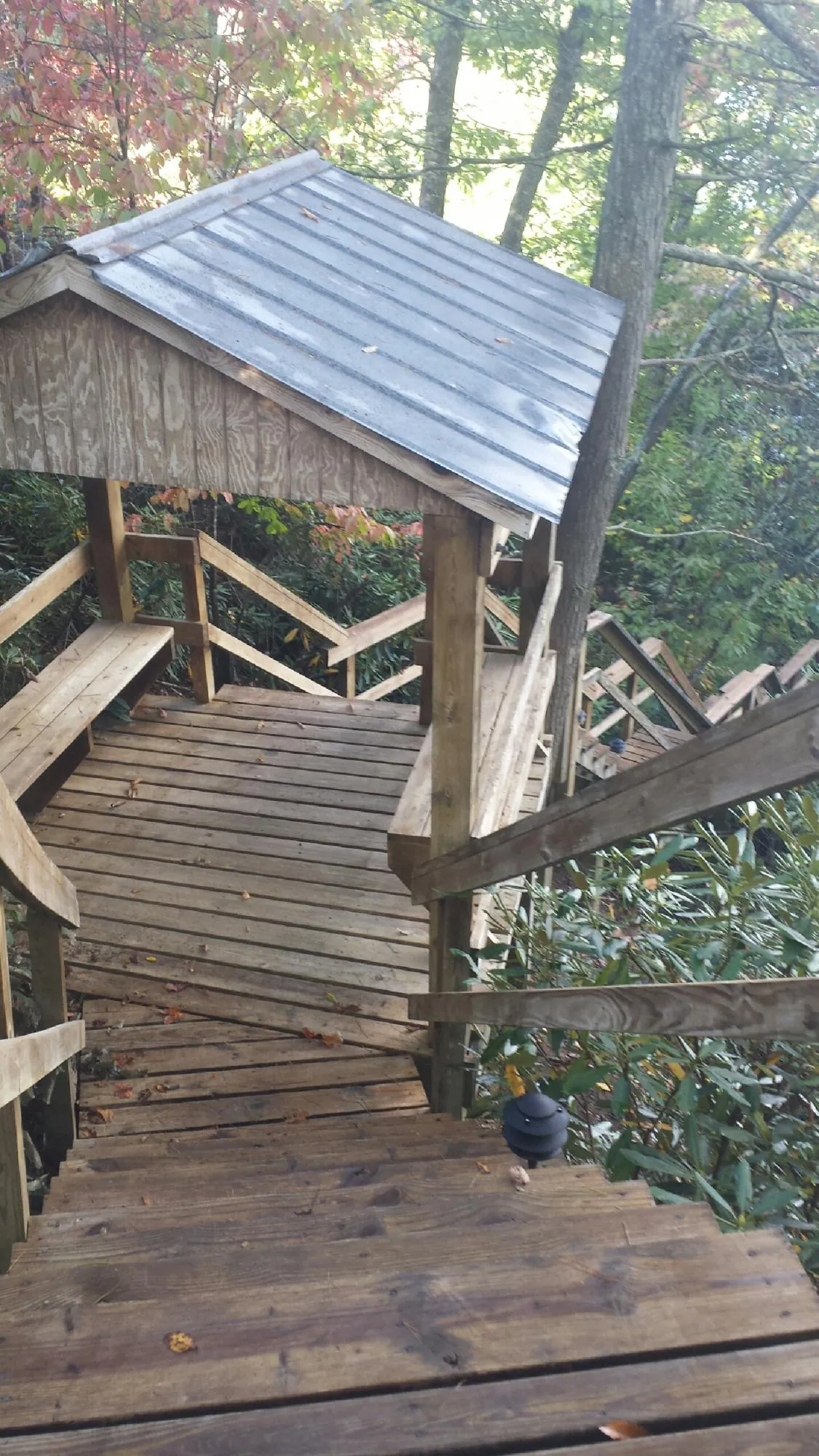 Metal roofed shelter over wooden steps on a wooded walkway — Skylight Repair & Installation work by our crew in Keenesburg