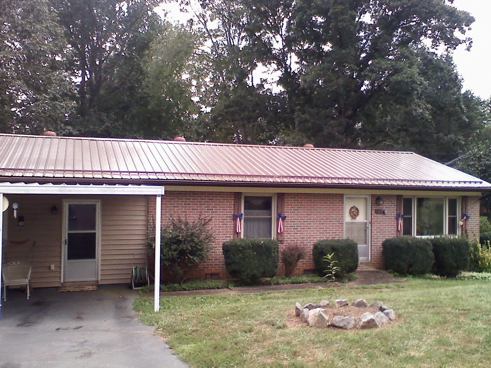 Bronze metal roof and carport on a brick ranch home — Roof Repair work by our crew in Keenesburg